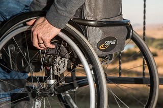 image of wheelchair wheel with hand