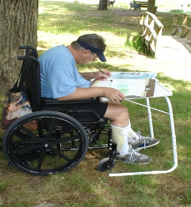 Man seated in wheelchair painting
